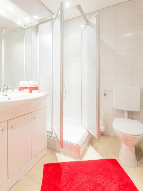 Badezimmer im Gasthof Menüwirt — Dusche, WC und Waschtisch