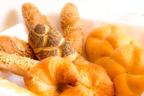 Frisches Gebäck — Croissant, Mohnhörnchen und Sesamstangen