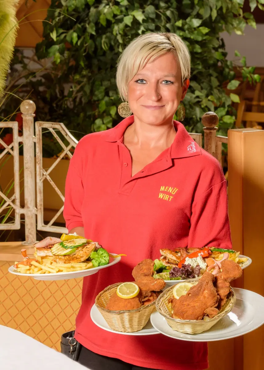 Kellnerin serviert Mittagsgerichte im Gasthof Menüwirt St. Kanzian