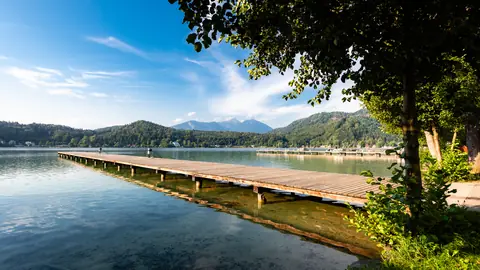 Holzsteg am Klopeiner See mit türkisem Wasser und Bergpanorama
