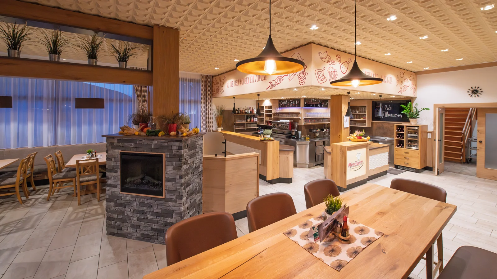Gemütlicher Gastraum im Restaurant Menüwirt mit Holztischen und warmer Abendbeleuchtung